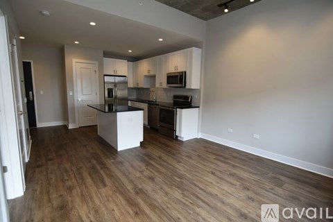 A kitchen with white cabinets and a wooden floor.
