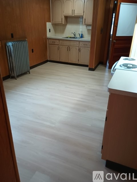 A kitchen with wooden cabinets and a white stove top oven.
