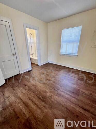 A room with wooden flooring and white walls.