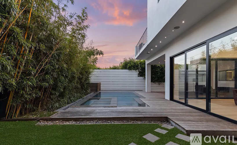 A modern house with a glass pool table in the backyard.