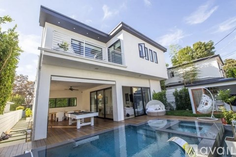 A modern house with a glass pool table in the backyard.