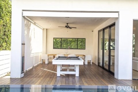 A modern kitchen with a wooden table and a chandelier.