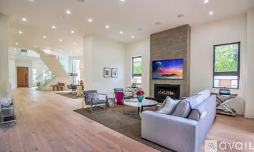 A living room with a grey couch and a fireplace.