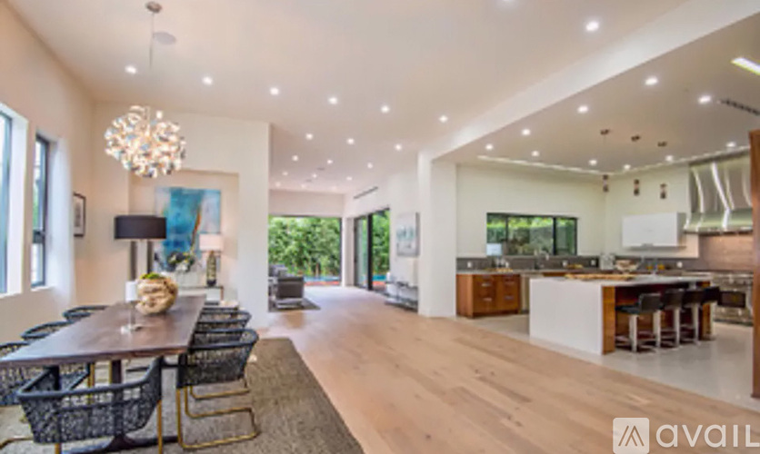 A modern dining room with a wooden table and chairs.