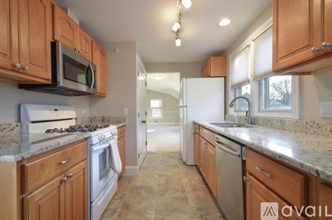 A kitchen with wooden cabinets and granite countertops.