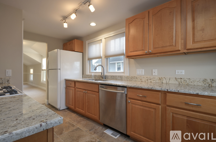 A kitchen with wooden cabinets and a marble countertop.