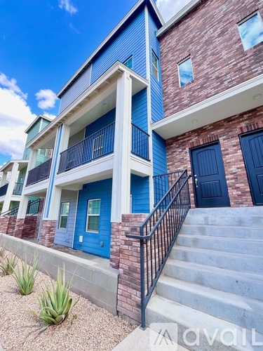 A blue and white building with a black railing on the stairs.