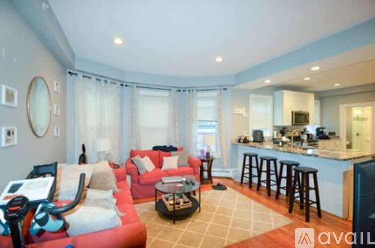 A living room with a red couch and a bar area.