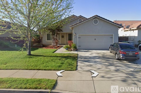 A house with a tree in front and a car parked in the driveway.