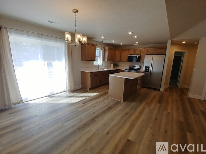 A spacious room with wooden flooring and a ceiling fan.