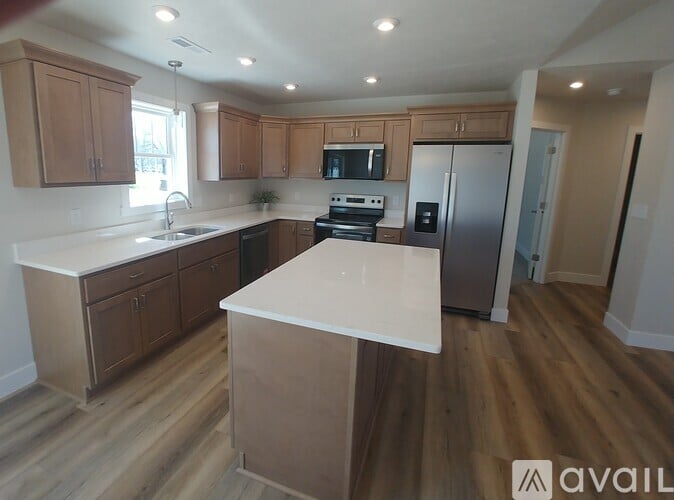 A kitchen with wooden cabinets and a white island.