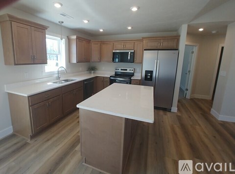 A kitchen with wooden cabinets and a white island.