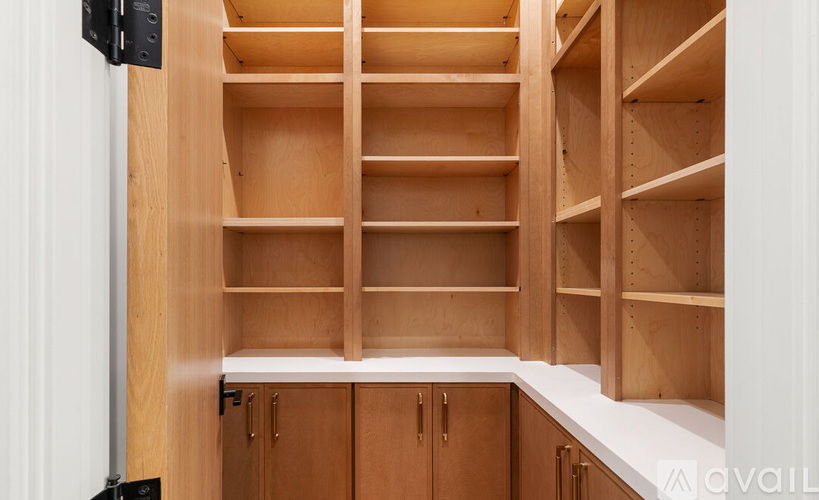 A kitchen with wooden cabinets and shelves.