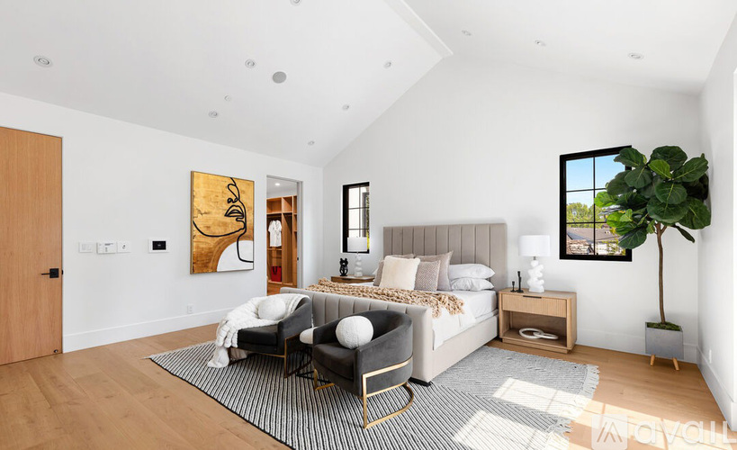A modern bedroom with a large bed and a grey and white rug.