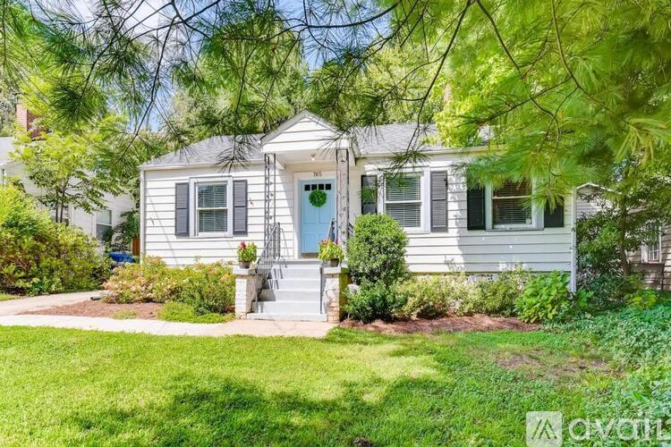 A white house with a green door and a small porch.