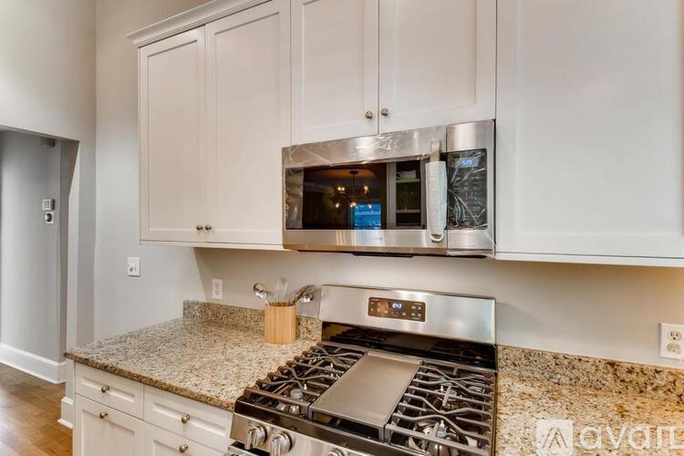 A kitchen with a stove top oven and cabinets.