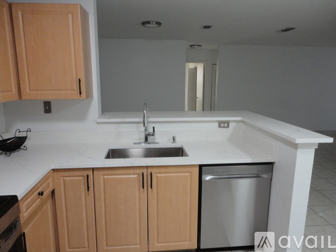A kitchen with wooden cabinets and a stainless steel dishwasher.