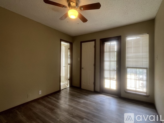 A room with a ceiling fan and wooden flooring.