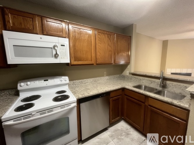 A kitchen with a white stove top oven and a white microwave above it.