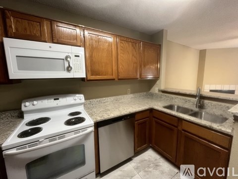 A kitchen with a white stove top oven and a white microwave above it.