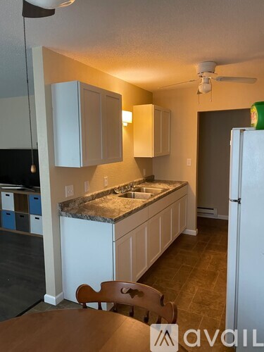 A kitchen with wooden cabinets and a white refrigerator.