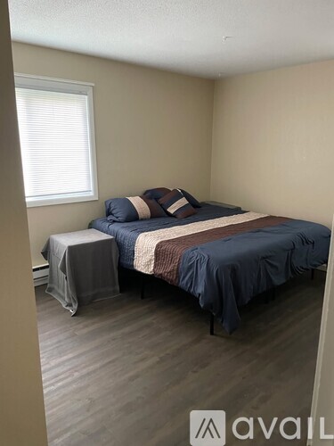 A bedroom with a bed and a small table.