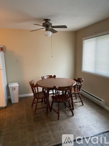 A dining room with a table and chairs.