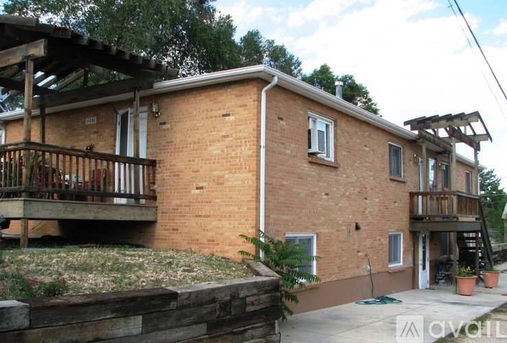 A brick house with a wooden balcony and a stone wall.