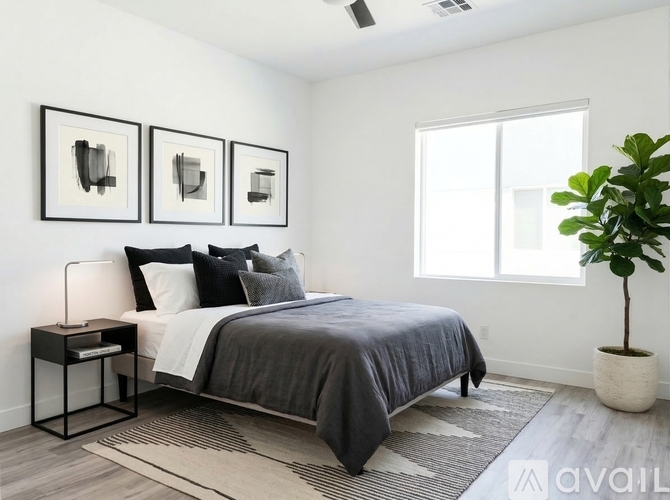 A bedroom with a bed, nightstand, and three wall art pieces.