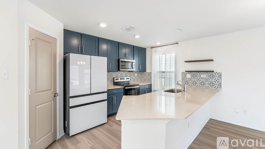 A kitchen with a white refrigerator and cabinets.