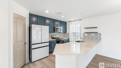 A kitchen with a white refrigerator and cabinets.