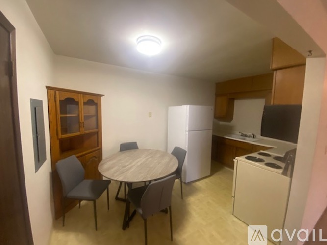A kitchen area with a table and chairs.