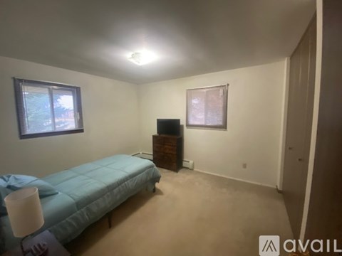 A bedroom with a bed, dresser, and window.