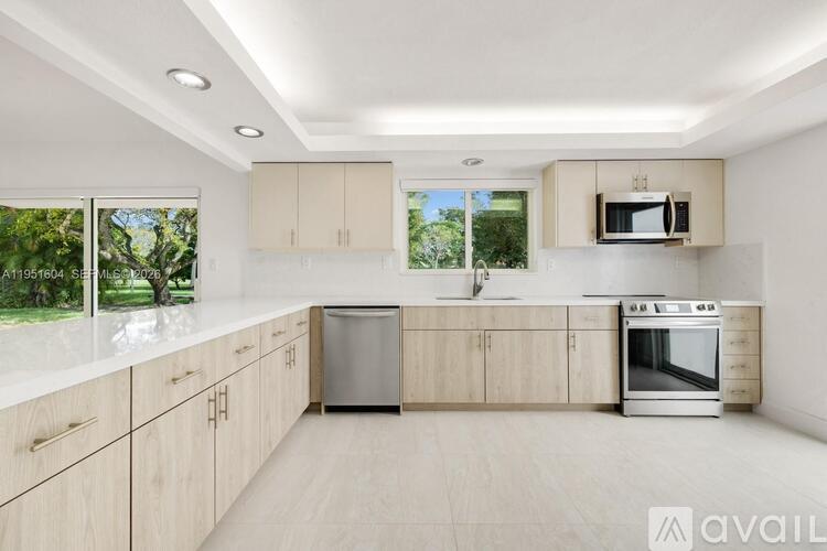 A modern kitchen with wooden cabinets and stainless steel appliances.