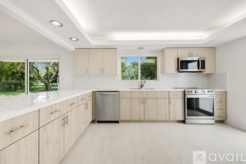 A modern kitchen with wooden cabinets and stainless steel appliances.