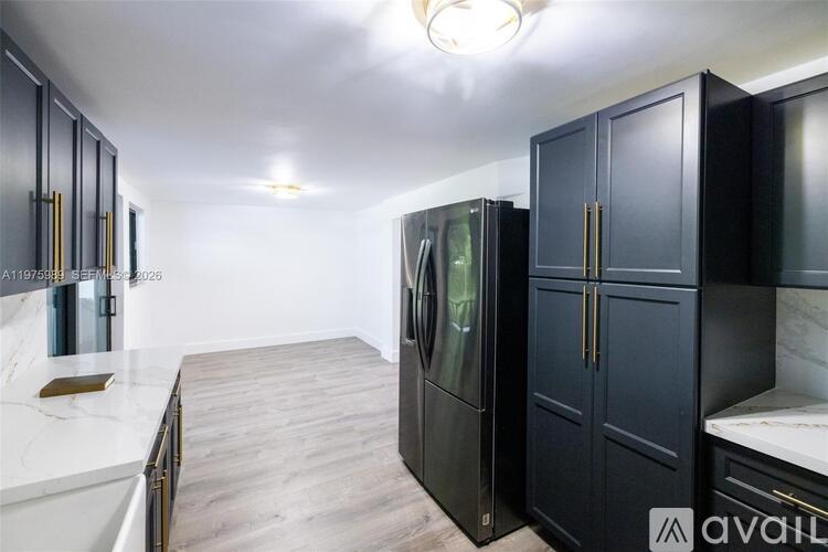 A kitchen with black cabinets and a white countertop.