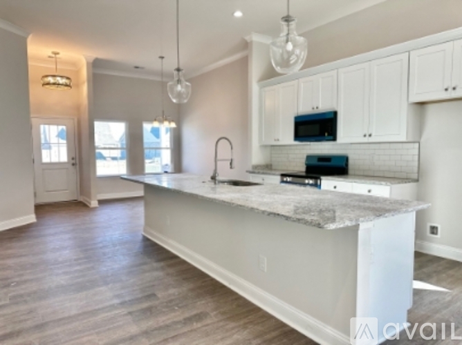 A kitchen with a marble countertop and white cabinets.