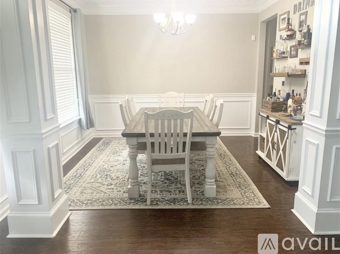A dining room with a table and chairs.