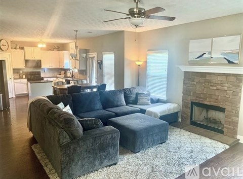 A living room with a grey couch and a fireplace.