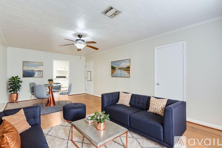 A living room with a blue couch and a ceiling fan.