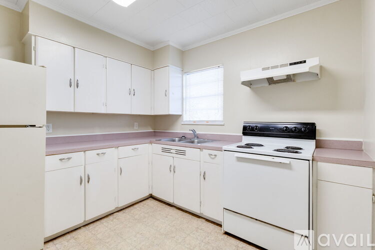 A kitchen with white cabinets and a black stove top oven.
