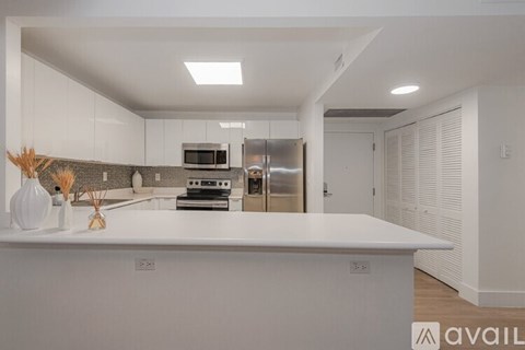 A modern kitchen with white cabinets and appliances.