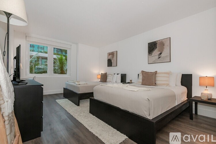 A bedroom with two beds and a television.
