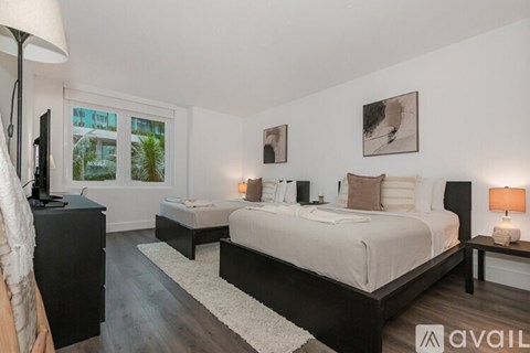 A bedroom with two beds and a television.