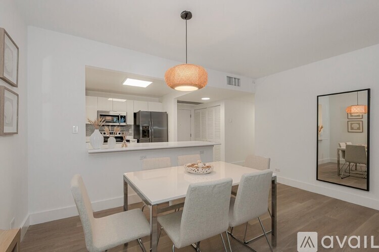 A modern dining room with a white table and chairs.