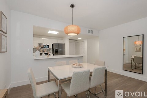 A modern dining room with a white table and chairs.