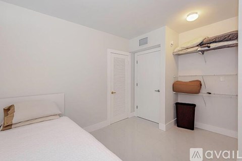 A bedroom with a white bed and a white closet.