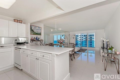 A modern kitchen with white cabinets and a large island.