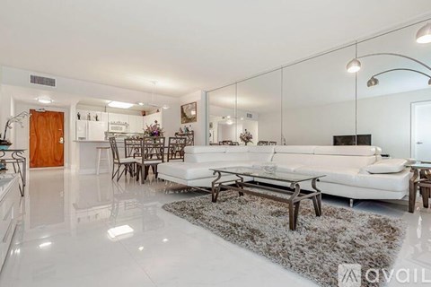 A modern living room with a white sofa and a glass wall.