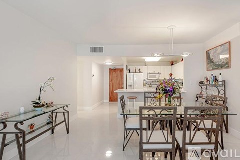 A modern dining room with a glass table and chairs.